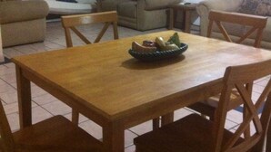 A dining area with a wooden table and four chairs. There is a bowl of fruit on the table. - Departamento Zona Dorada Mazatlán 6 (Mazatlán)