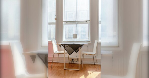 A room with a table and two chairs, a window, and a lamp.