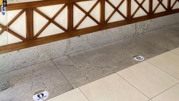 Un mostrador de recepción con diseño de panel de madera, un monitor Samsung y una balanza digital.