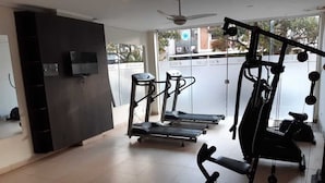 Un gimnasio con cintas de correr, una prensa de pesas y una jaula para sentadillas.