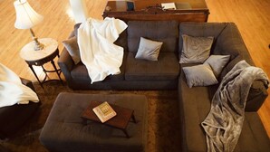 Una sala de estar acogedora con un sofá modular, una mesita auxiliar y una mesa de centro.
