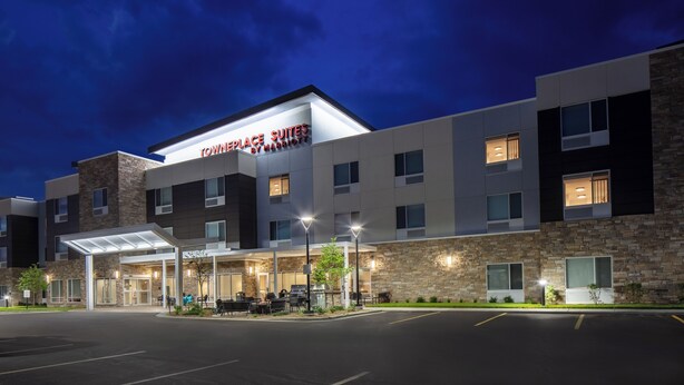 Un hotel moderno con un cartel que dice "Townplace Suites by Marriott" y un área de entrada cubierta.