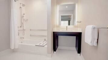 A modern bathroom with a walk-in shower, a bathtub, a vanity with a mirror, and a towel rack.