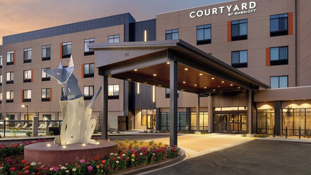 A Courtyard by Marriott hotel with a covered entrance, a pool, and a decorative sculpture. - Courtyard by Marriott Petaluma Sonoma County (Petaluma)