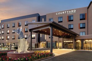 A Courtyard by Marriott hotel with a covered entrance, a pool, and a decorative sculpture. - Courtyard by Marriott Petaluma Sonoma County (Petaluma)