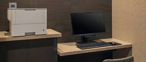 A modern office space with a printer, a computer monitor, and a chair.