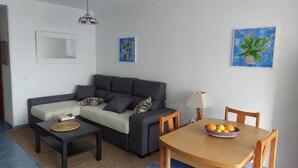 A living room with a sofa, a coffee table, a dining table with chairs, and two wall-mounted paintings. - 90 metres from the beach (PENISCOLA)