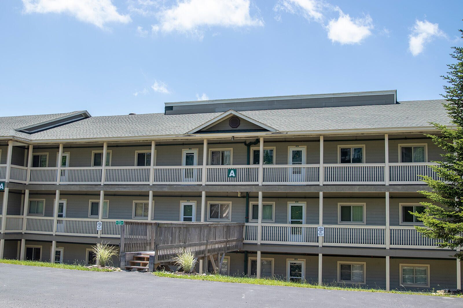 A multi-story motel with balconies and a covered walkway.