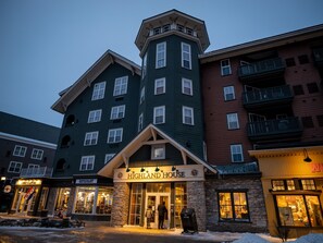 A multi-story building with a prominent corner tower, a restaurant named Highland House, and various storefronts. - HH 207: Ski-In/Out | Sunrise Views | Village Steps | Sleeps 4 (Snowshoe)