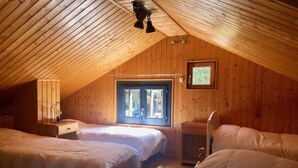 A cozy attic bedroom with two beds, a desk, and a window with a view of the outside. - Cosy chalet close to resorts and lake many activities summer/winter 10 pl. ⛷️🥾🦌 (Matemale)