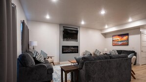 A modern living room with two sofas, a coffee table, and a fireplace.