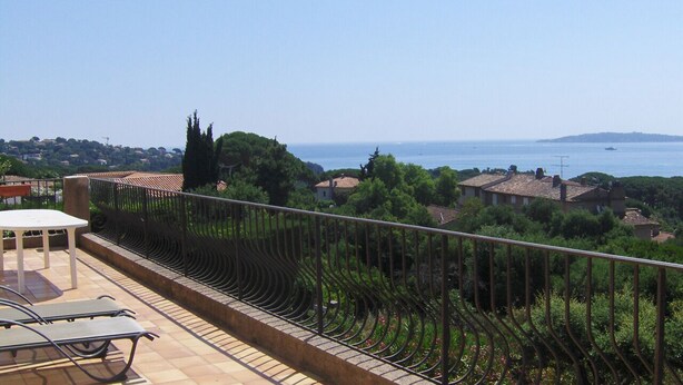 Una terraza con vistas al mar, una mesa y sillas.