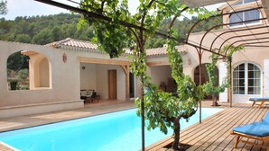 A pool area with a pergola, wooden deck, and outdoor seating. - Piscine Chauffée Privée - Parc Régional Naturel St (EVENOS)