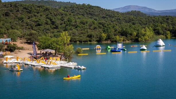 A lake with boats, a dock, and a forested hill in the background. - La Cigale Bleue à Callian (CALLIAN)