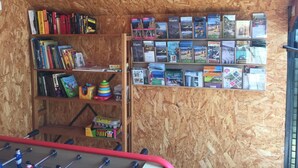 A room with wooden walls and shelves filled with books and travel magazines. - La Cigale Bleue à Callian (CALLIAN)