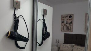 A bathroom with a large mirror, a sink, and two hair dryers mounted on the wall. - 6 Person - 1 - Bed Apartment in Blackpool (Blackpool)
