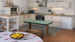 A compact kitchen with white cabinets, a microwave, a toaster, and a sink. - Les Volets Bleus - LA Garde Freinet (LA GARDE FREINET)