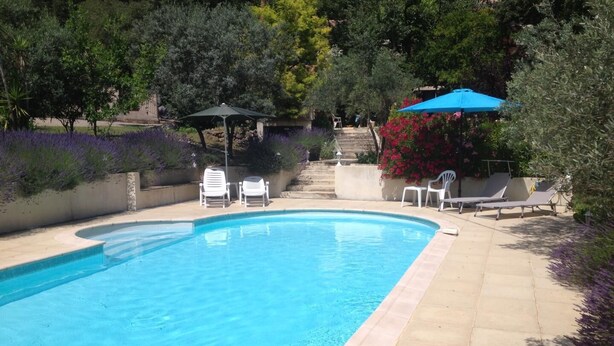 Una piscina amb gandules i una zona d'estar coberta.
