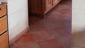 Een keuken met een houten kast en een betegelde vloer.