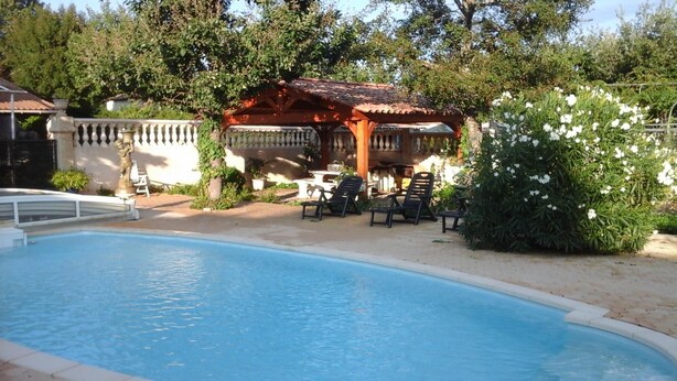Ein Pool mit Liegestühlen und einer Pergola.