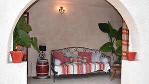 Un coin salon confortable avec un banc rembourré, une lampe et des plantes en pot.