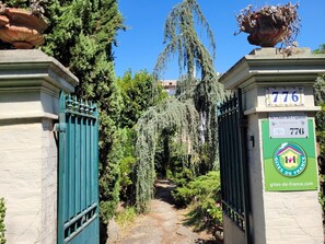 A gated entrance with a sign indicating '776' and 'Au Chant des Cigalous'.