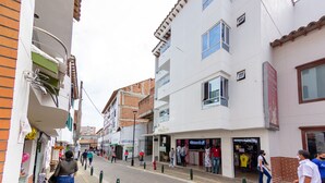 Une vue de rue avec un hôtel, des boutiques et des piétons.