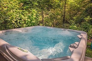 A hot tub surrounded by lush greenery.