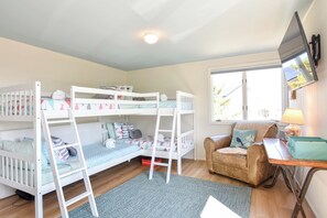 A room with bunk beds, a desk, a chair, and a window. - Dreamy Water Views w/ Central AC (Eastham)