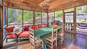 Un interior de madera con una mesa de comedor, sillas y un banco con cojines.