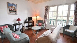 A living room with a sofa, armchairs, a small round table, a TV, and a lamp. - Hossegor "ENEA" Pleasant villa for 6 people. (HOSSEGOR)