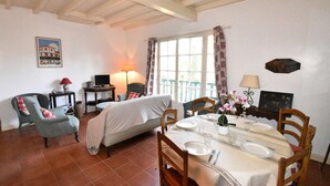 A dining area with a table set for four, a sofa, and a lamp. - Hossegor "ENEA" Pleasant villa for 6 people. (HOSSEGOR)