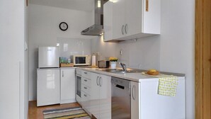 A modern kitchen with white cabinets, a microwave, a toaster, and a dishwasher. - Studio with Terrace – Nature Stay near Terme Čatež (Ribnica)
