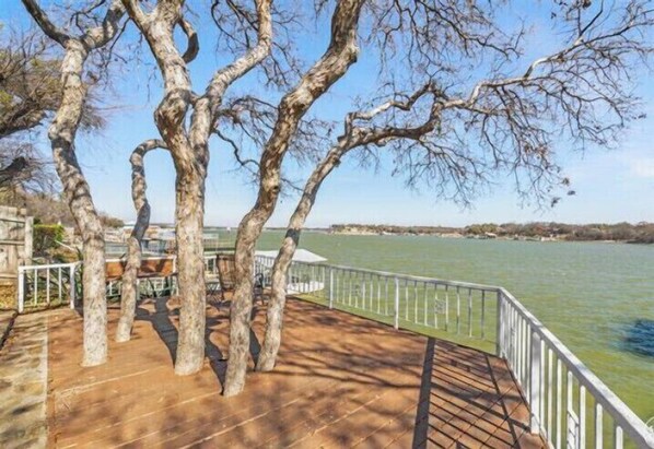 A wooden deck with a railing overlooking a body of water.