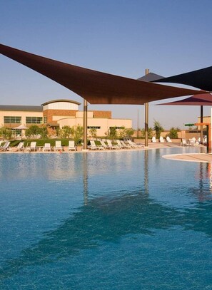 A swimming pool with lounge chairs and umbrellas, surrounded by buildings with a modern architectural style. - DESERT GEM!  Resort style Living - Private Pool. (Florence)