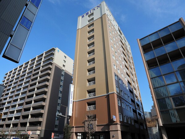 A multi-story hotel with a prominent 'Yokohama Inn' sign, featuring a modern architectural design with balconies and a clear sky in the background. - Toyoko Inn Toride-eki Higashi-guchi (Toride)