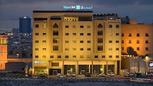 A hotel with a modern facade, multiple floors, and a prominent signage indicating it is a Tripper Inn. - Tripper Inn (Dammam)