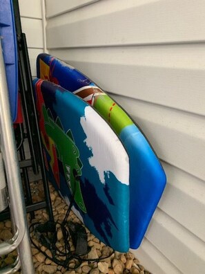 Bunte, mit Haien bedruckte Outdoor-Kissen lehnen an einer weißen Wand.