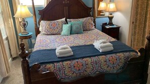 A bed with a patterned bedspread, two pillows, and two folded towels. There are two bedside lamps and a mirror on the wall. -  Elevated Apt steps from beach. Furnished Parking Utilities, TV Internet Include (Tybee Island)