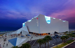 A modern architectural building with a unique wavy roof design, surrounded by a spacious plaza with palm trees and a parking area. - Hotel Time Melaka (Malacca City)