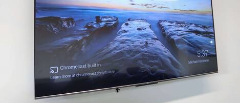 A flat-screen TV displaying a scenic beach sunset with a message about Chromecast.