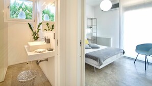 Een moderne slaapkamer met een bed, nachtkastje en een groot raam.
