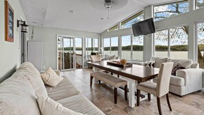 Un salon spacieux avec une grande table à manger, des sièges confortables et une vue sur l’extérieur.