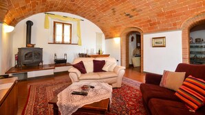 A cozy living room with a brick ceiling, a sofa, a red couch, a wooden coffee table, and a fireplace. - Antinoro 1, Montelupo Fiorentino, Italy (Montelupo Fiorentino)