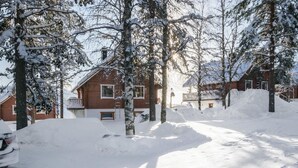 A snow-covered street with houses and trees.