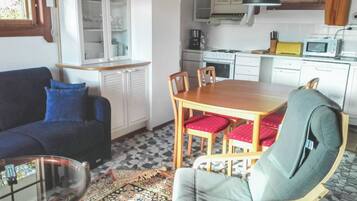 Een koelkast, een magnetron, een vaatwasser, kookgerei, borden en bestek