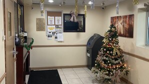 A reception area with a Christmas tree, a bulletin board, and a desk with a computer.