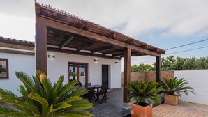 A covered patio with a table and chairs, surrounded by potted plants. - Chalet Conil Ramirez with private pool (Conil de la Frontera)