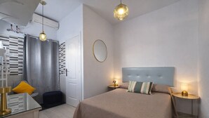 Ein modernes Schlafzimmer mit einem großen Bett, Nachttischen, einem Spiegel und einer Hängeleuchte.