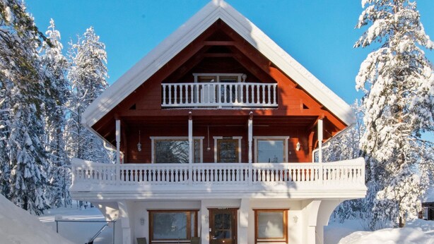 A wooden cabin with a balcony, surrounded by snow-covered trees. - Kulma-alpit b by Interhome (Hyrynsalmi)